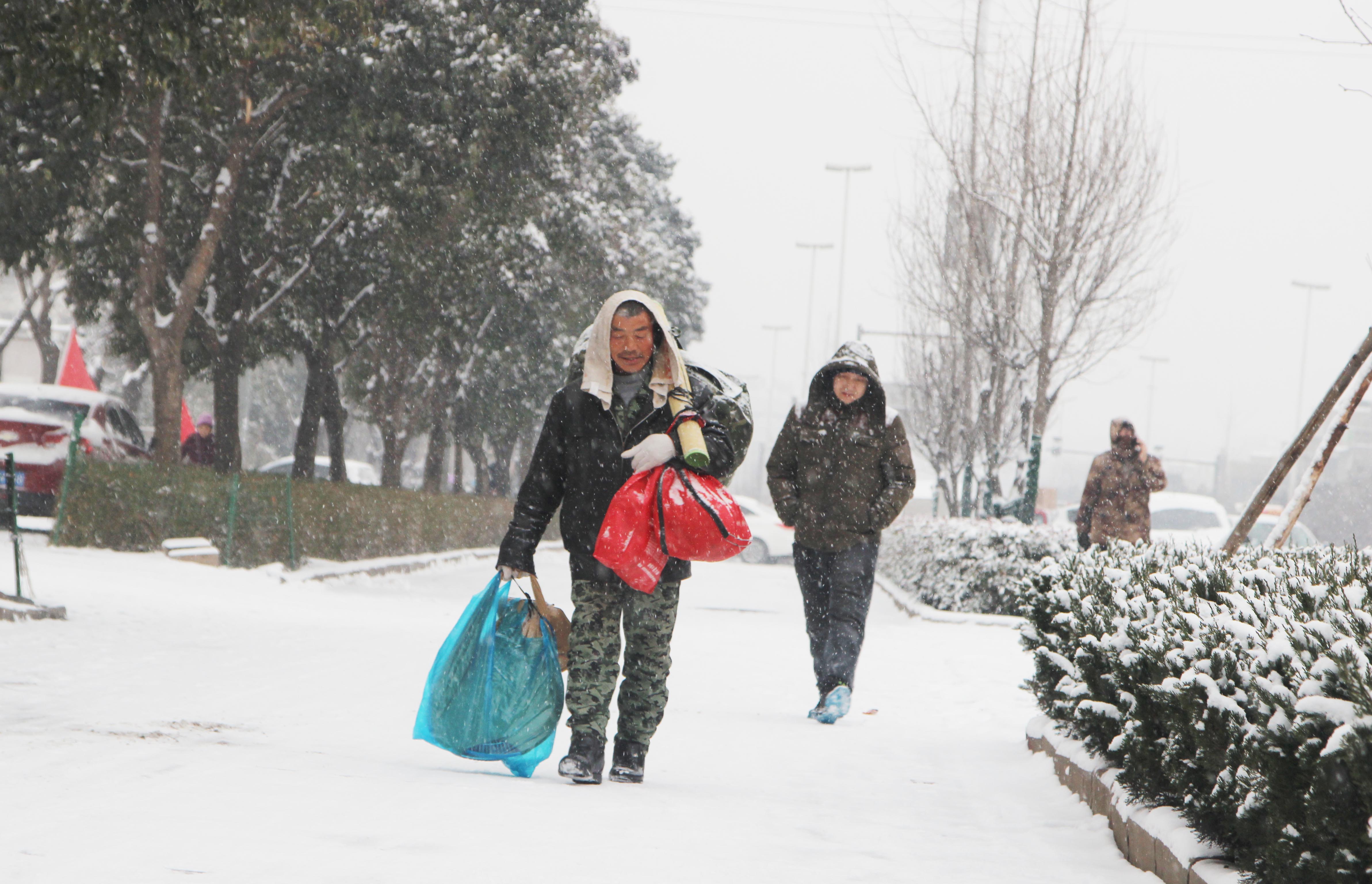 大雪阻路，女子坚守车站等待两天回家过年